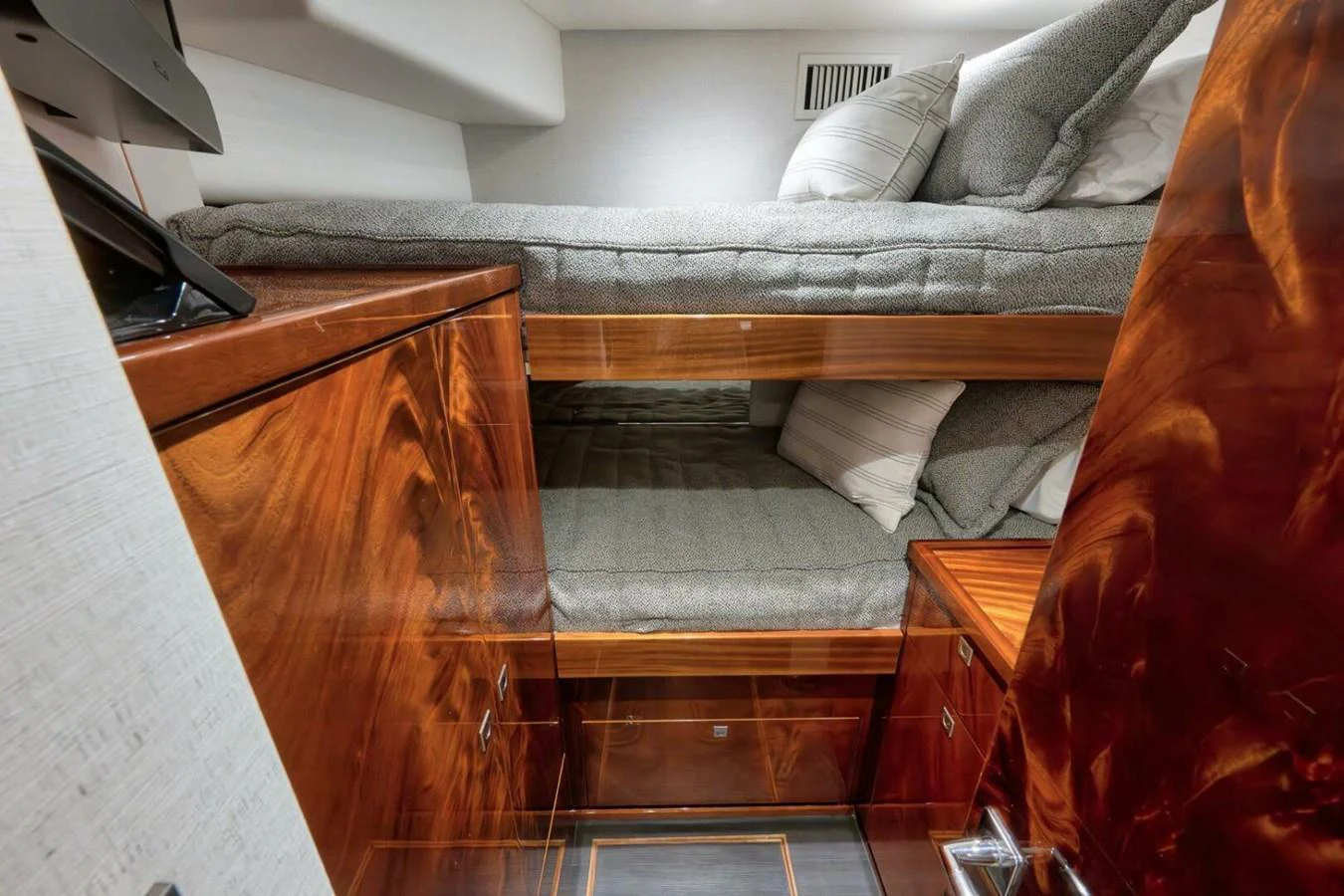 The image showcases a cozy cabin with bunk beds and rich wooden cabinetry. aboard NIKKI BELLA Yacht for Sale