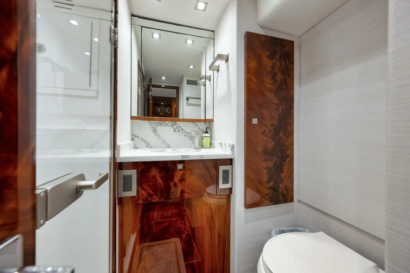 The yacht's bathroom features luxurious wood accents and a sleek, modern design. aboard NIKKI BELLA Yacht for Sale
