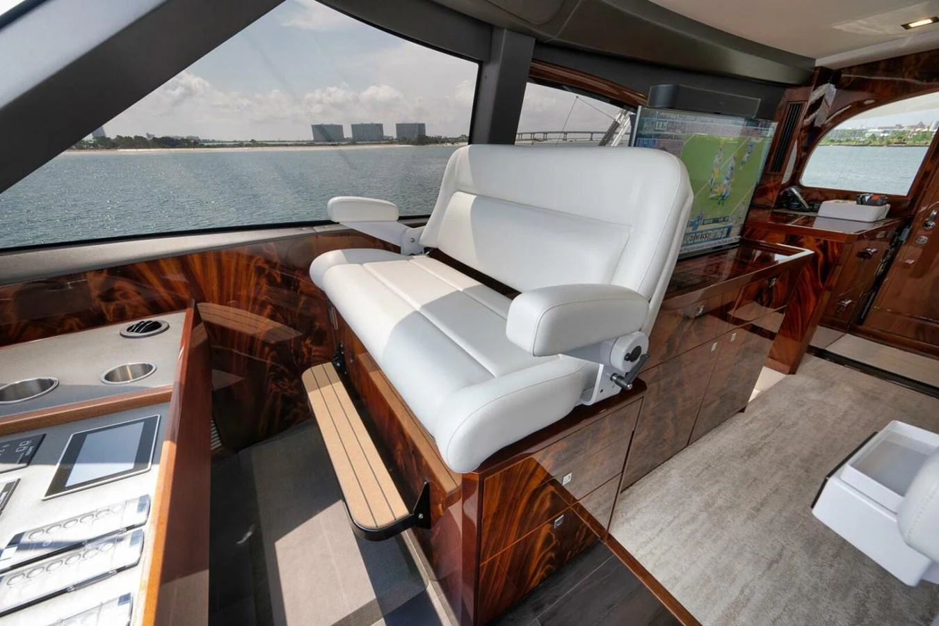 The helm station features a luxurious white captain's chair with a panoramic view of the water. aboard NIKKI BELLA Yacht for Sale