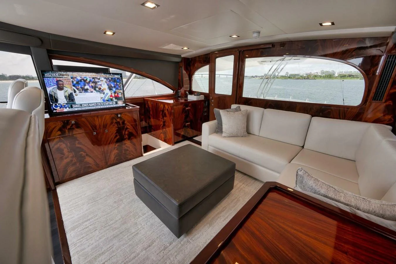 The salon features luxurious seating and a large TV, with expansive windows offering stunning views. aboard NIKKI BELLA Yacht for Sale