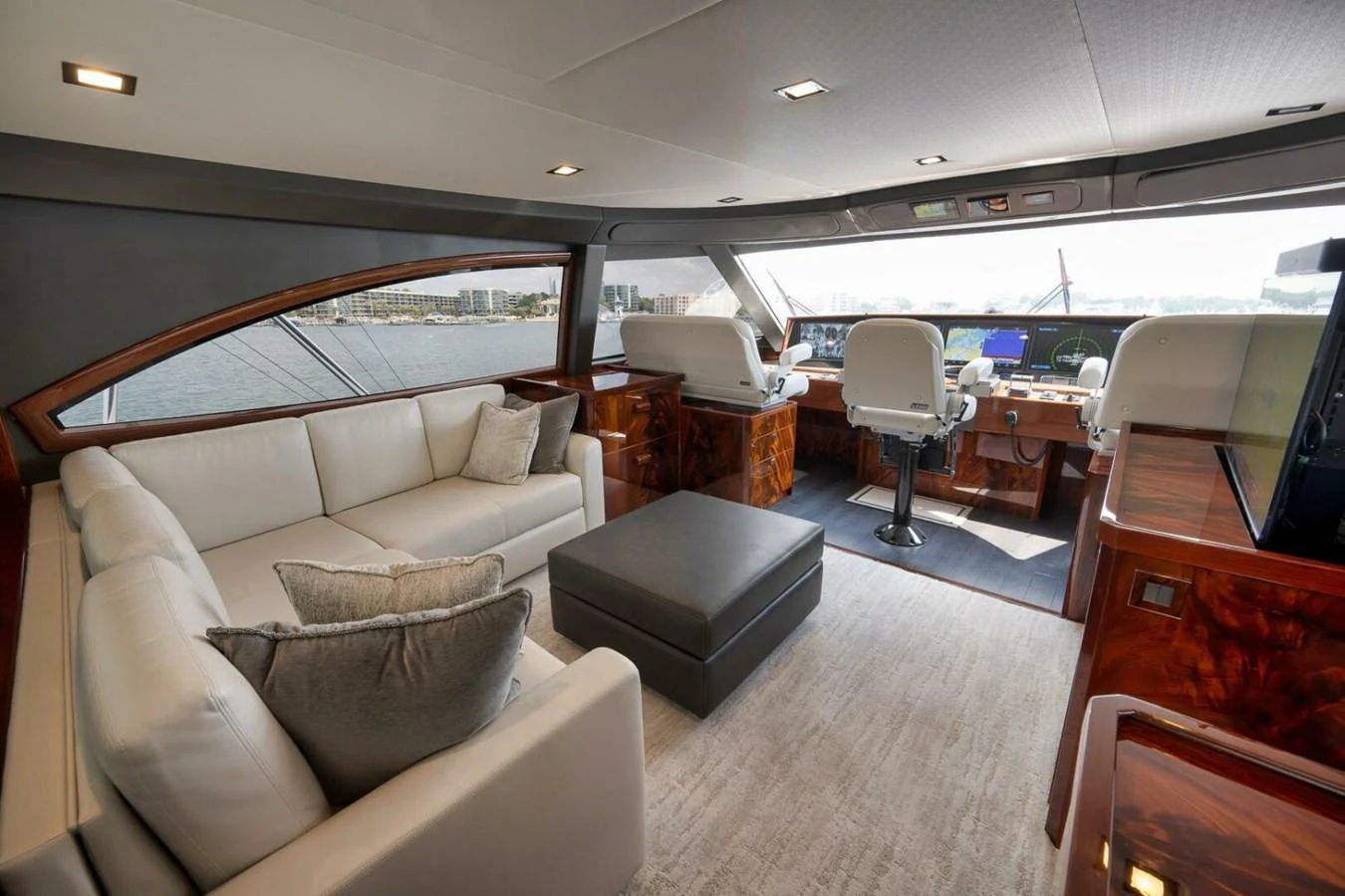 The salon features a comfortable seating area with a view of the helm and large windows offering panoramic views. aboard NIKKI BELLA Yacht for Sale