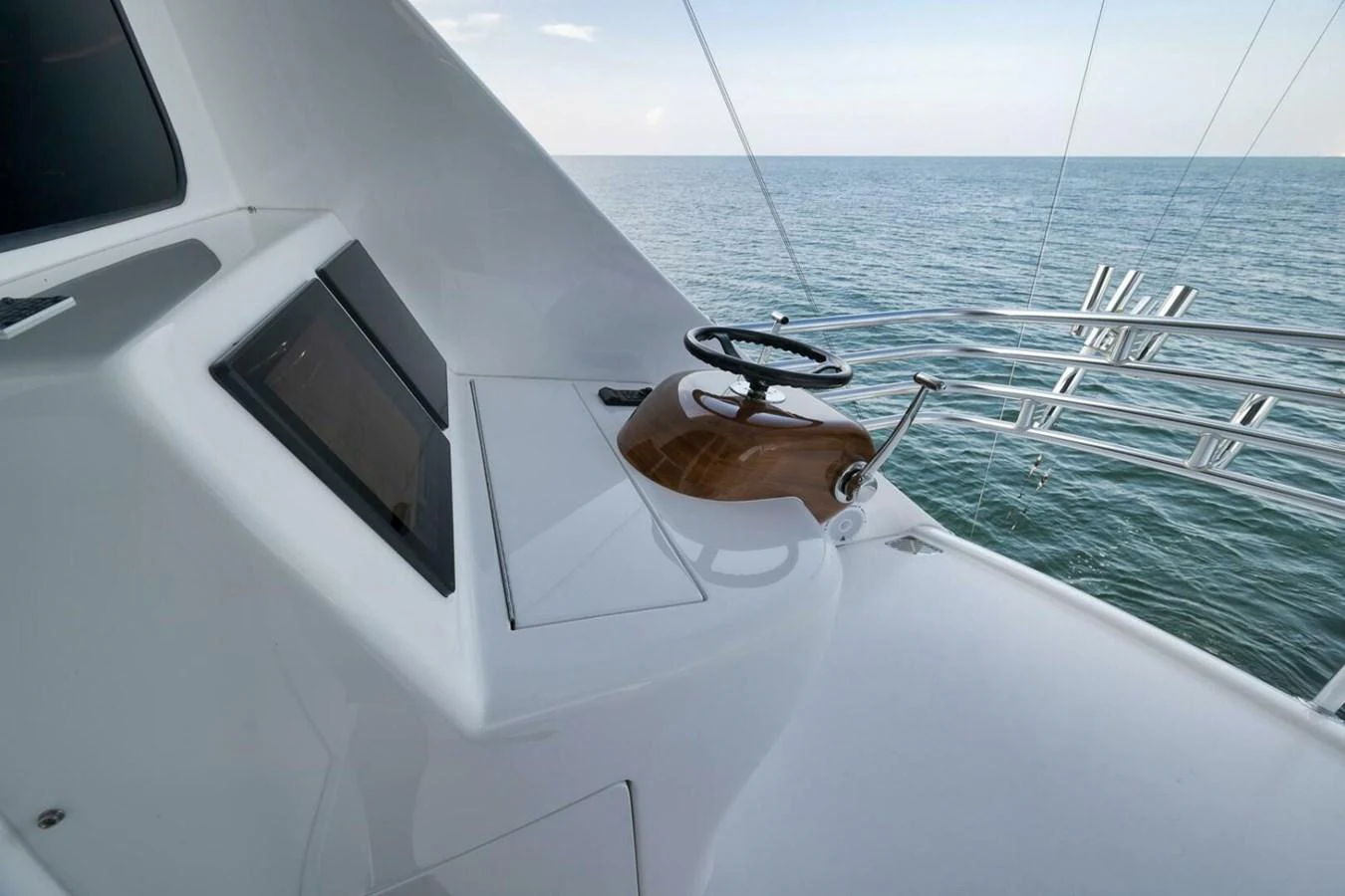 A sleek and modern helm station with a polished wooden wheel and advanced navigation equipment. aboard NIKKI BELLA Yacht for Sale
