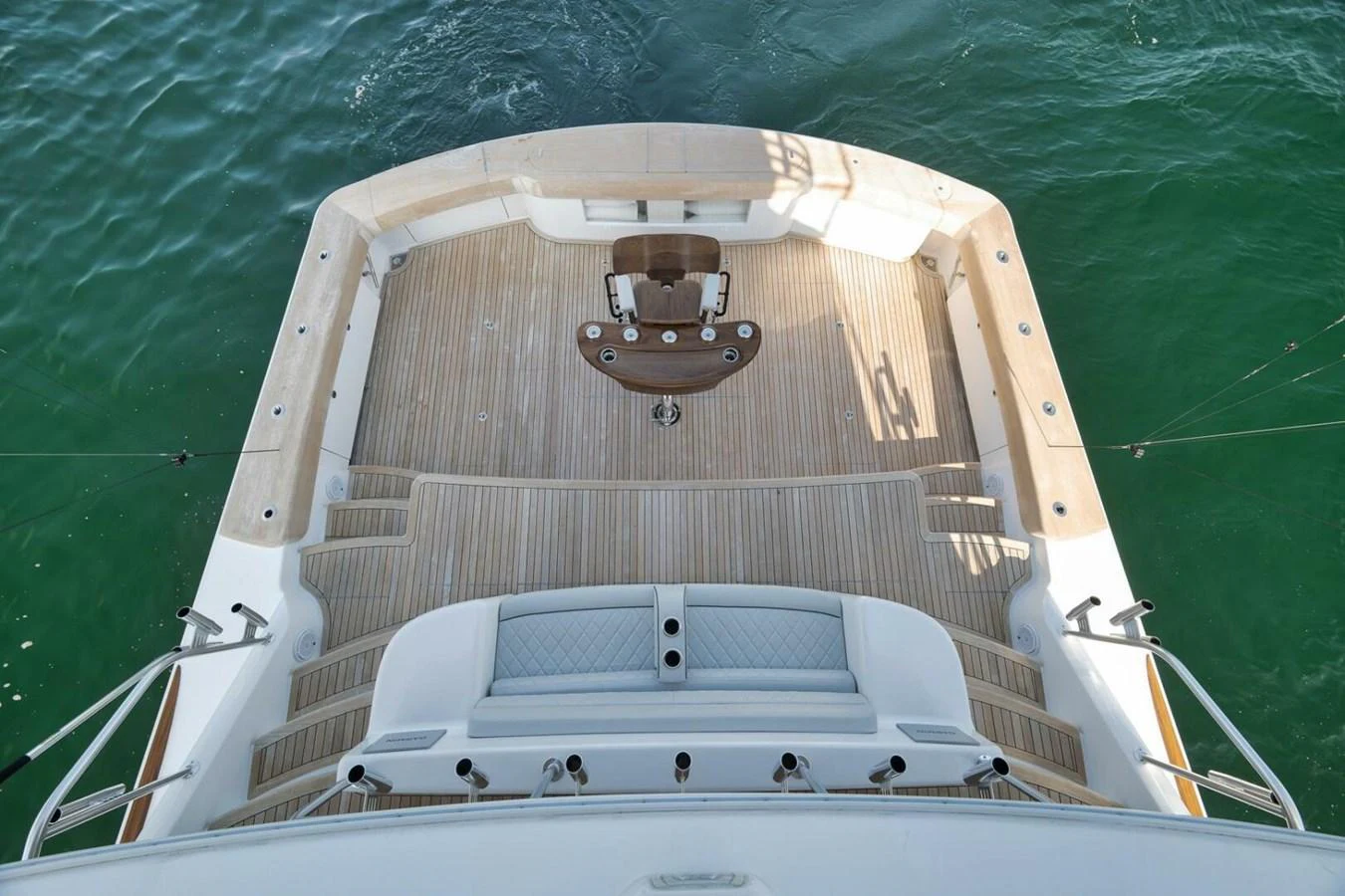 The yacht's aft deck features a spacious and inviting area with elegant wooden flooring and a central seating arrangement, perfect for relaxation and socializing. aboard NIKKI BELLA Yacht for Sale
