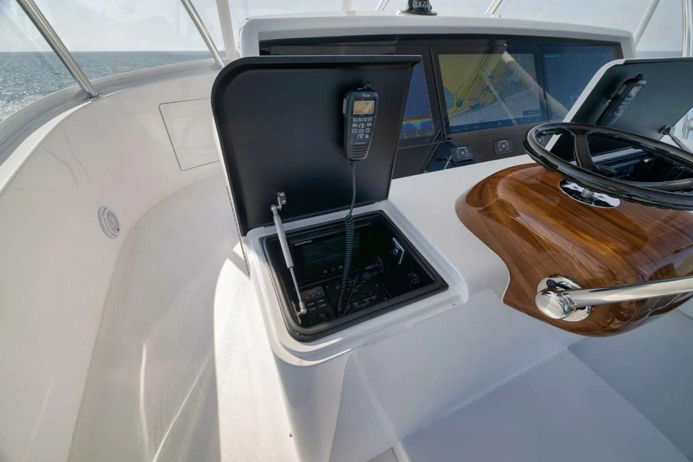 The helm station features a sleek design with modern navigation equipment and a polished wooden steering wheel. aboard NIKKI BELLA Yacht for Sale