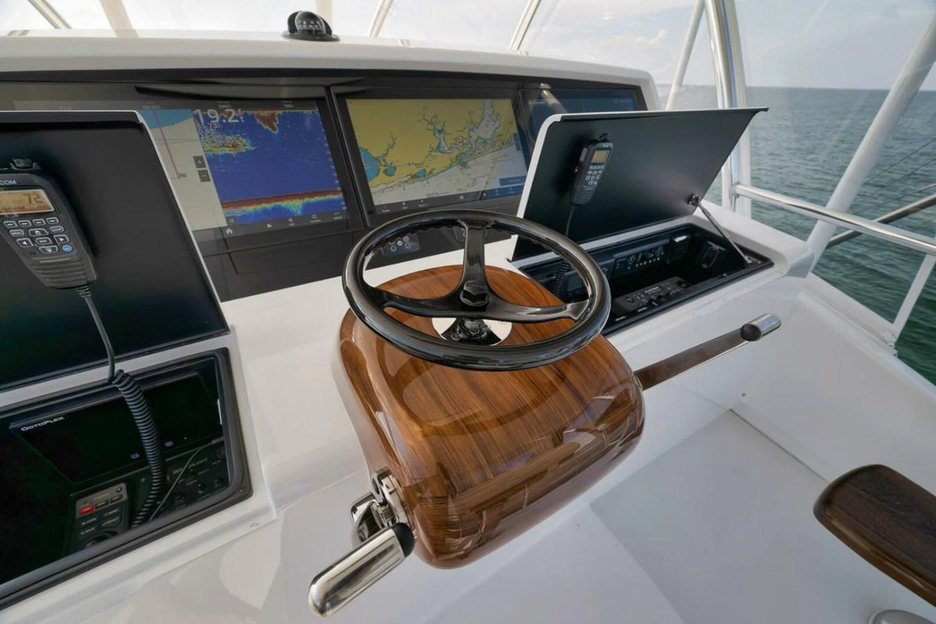 The helm station features advanced navigation equipment and a polished wooden steering wheel. aboard NIKKI BELLA Yacht for Sale