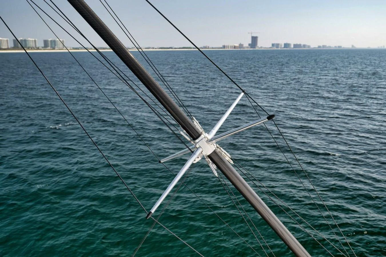 A detailed view of the yacht's rigging against a backdrop of calm waters and a distant shoreline. aboard NIKKI BELLA Yacht for Sale