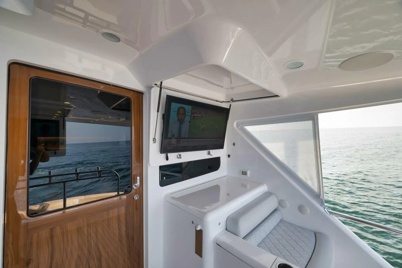 The yacht's salon features a comfortable seating area with a television and a view of the sea. aboard NIKKI BELLA Yacht for Sale
