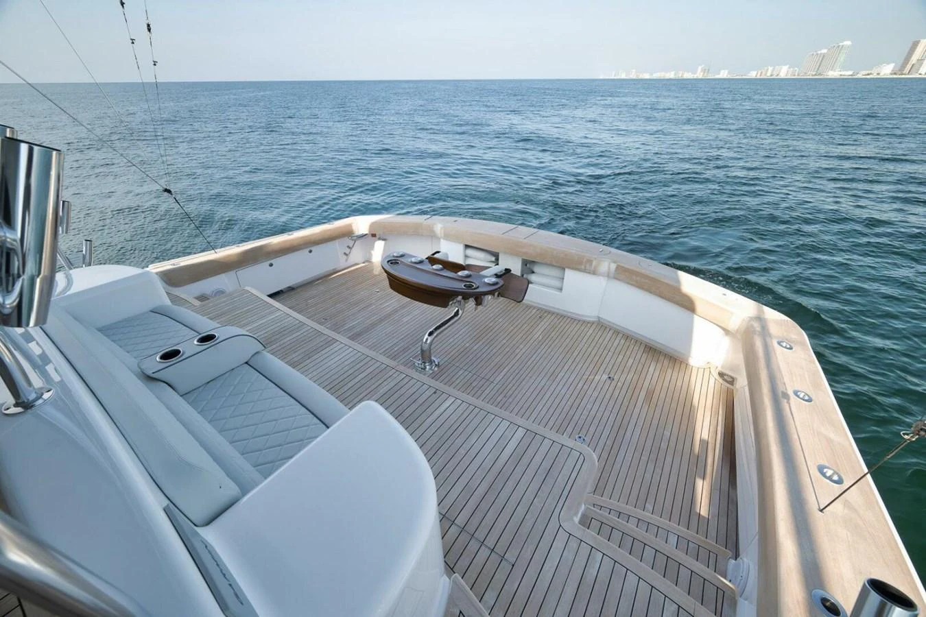 The yacht's aft deck features a spacious and elegant teak layout with comfortable seating and a central table, perfect for outdoor relaxation. aboard NIKKI BELLA Yacht for Sale
