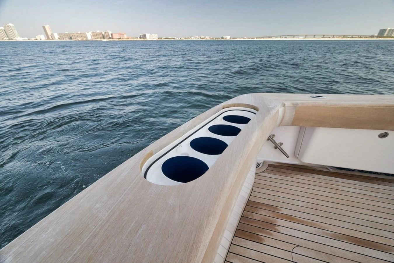 A close-up view of the yacht's deck featuring built-in cup holders and a wooden finish. aboard NIKKI BELLA Yacht for Sale