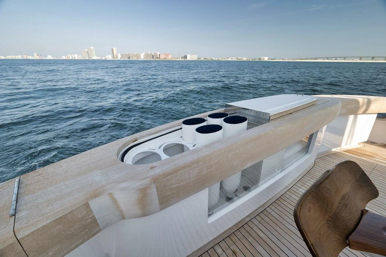 The image showcases a detailed view of the yacht's deck with a built-in storage area and a scenic ocean backdrop. aboard NIKKI BELLA Yacht for Sale