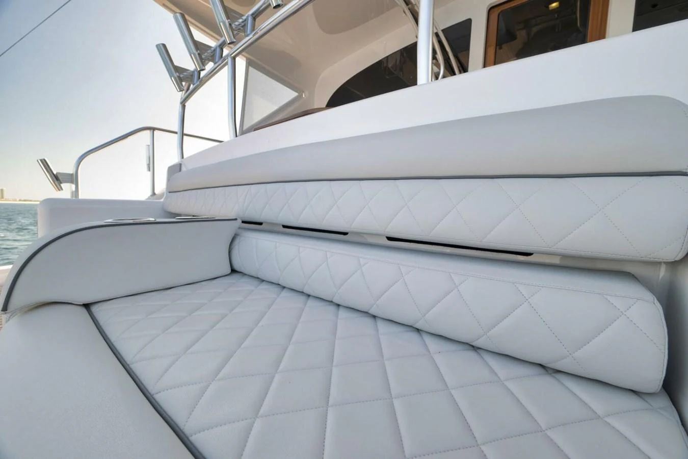 The image showcases a luxurious, quilted seating area on the yacht. aboard NIKKI BELLA Yacht for Sale