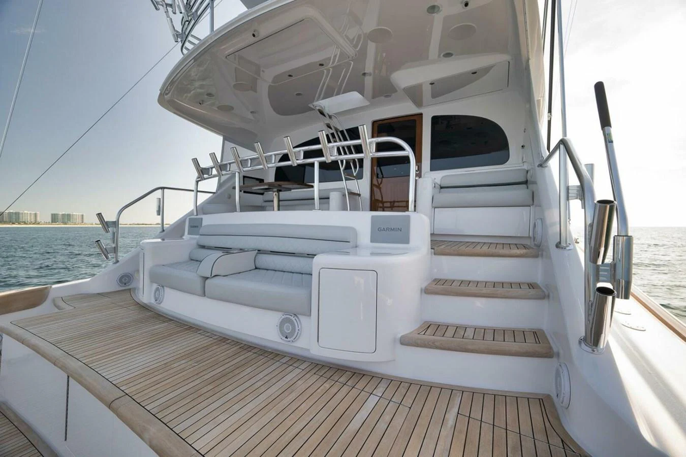 The aft deck features elegant seating and a staircase leading to the upper deck, with a view of the water in the background. aboard NIKKI BELLA Yacht for Sale