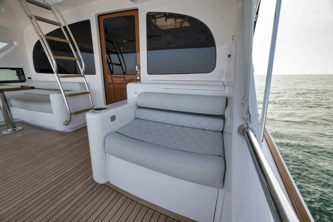 The aft deck features a comfortable seating area with a view of the ocean. aboard NIKKI BELLA Yacht for Sale