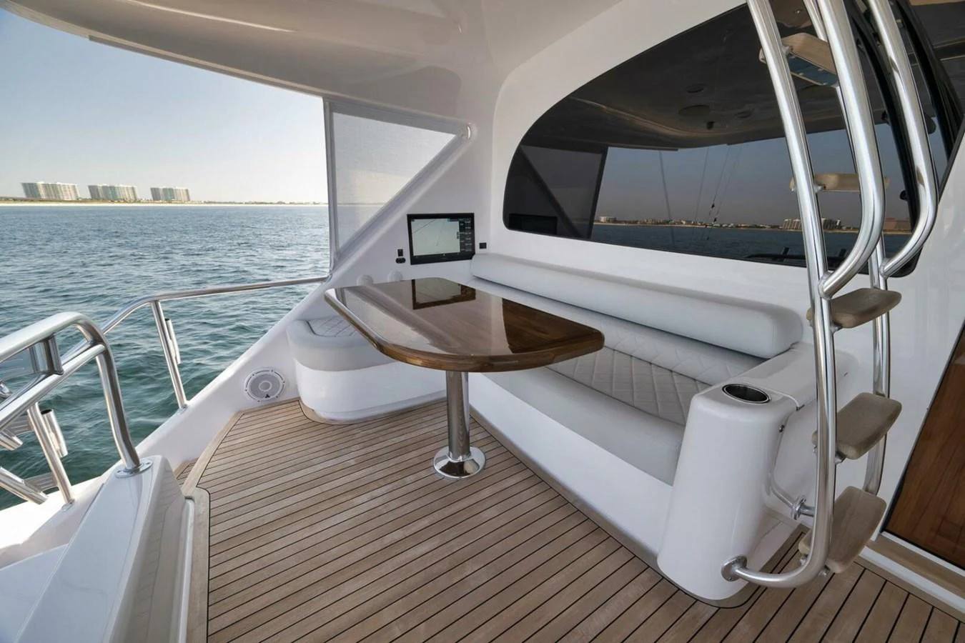The yacht's saloon features a sleek, modern seating area with a polished wooden table and expansive windows offering stunning ocean views. aboard NIKKI BELLA Yacht for Sale