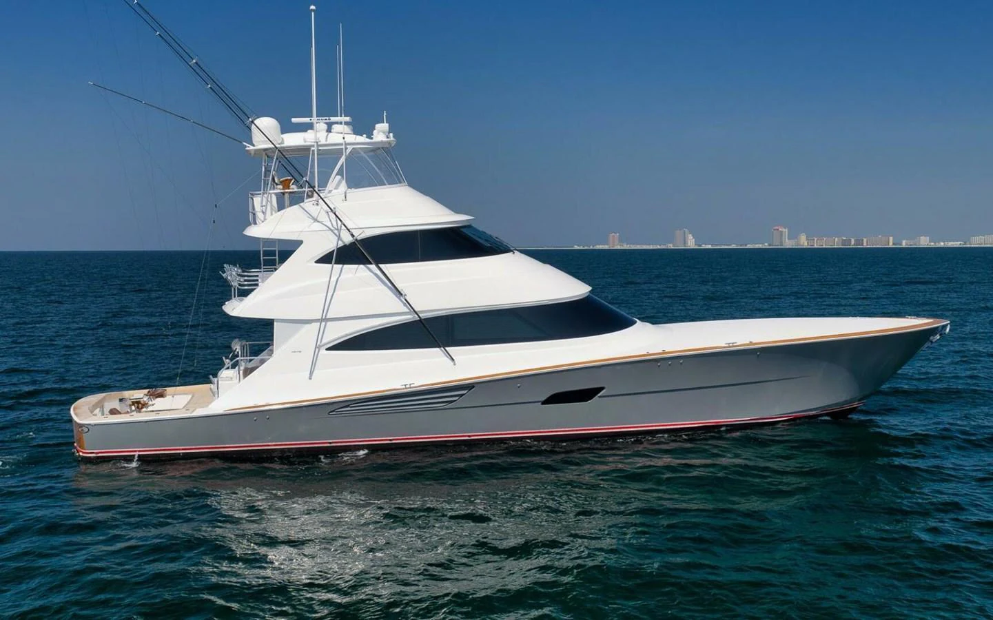 A sleek yacht cruising on the open water under a clear blue sky. aboard NIKKI BELLA Yacht for Sale