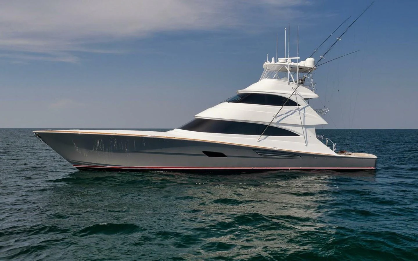 A sleek and modern yacht glides gracefully on the open water under a clear sky. aboard NIKKI BELLA Yacht for Sale