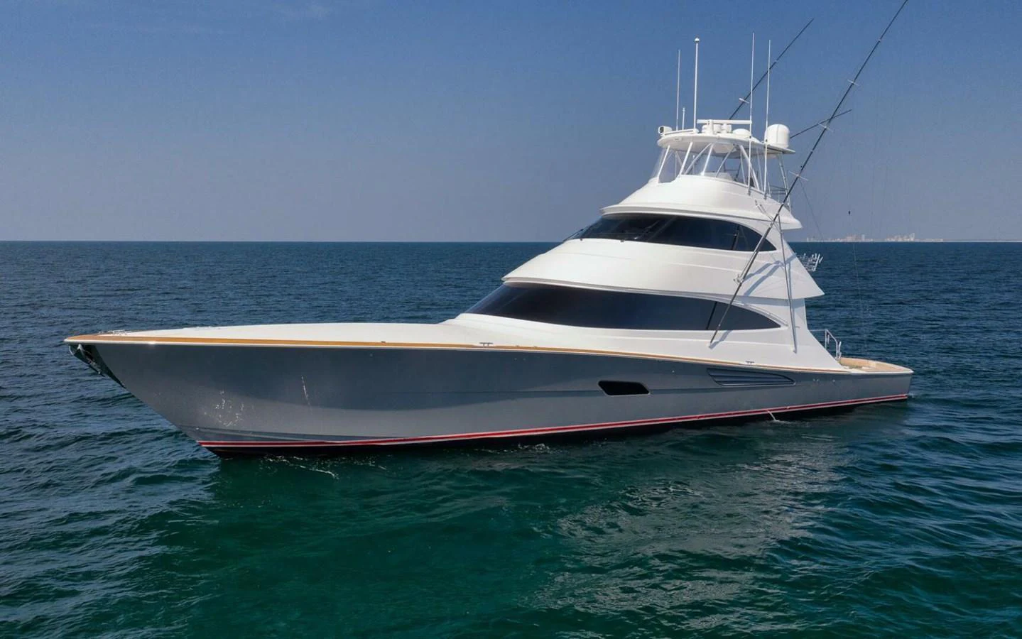 A sleek and modern yacht glides effortlessly on calm waters under a clear blue sky. aboard NIKKI BELLA Yacht for Sale