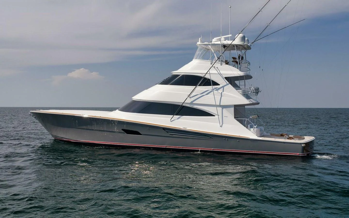 A sleek and modern yacht glides gracefully on the open sea under a clear sky. aboard NIKKI BELLA Yacht for Sale