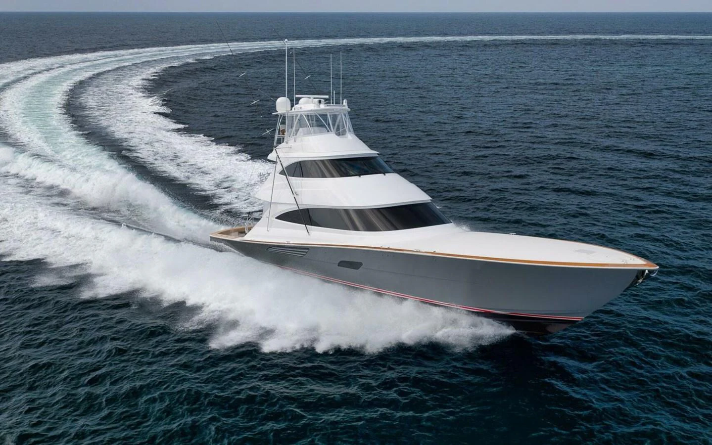 A sleek yacht cuts through the water, leaving a dynamic wake behind. aboard NIKKI BELLA Yacht for Sale