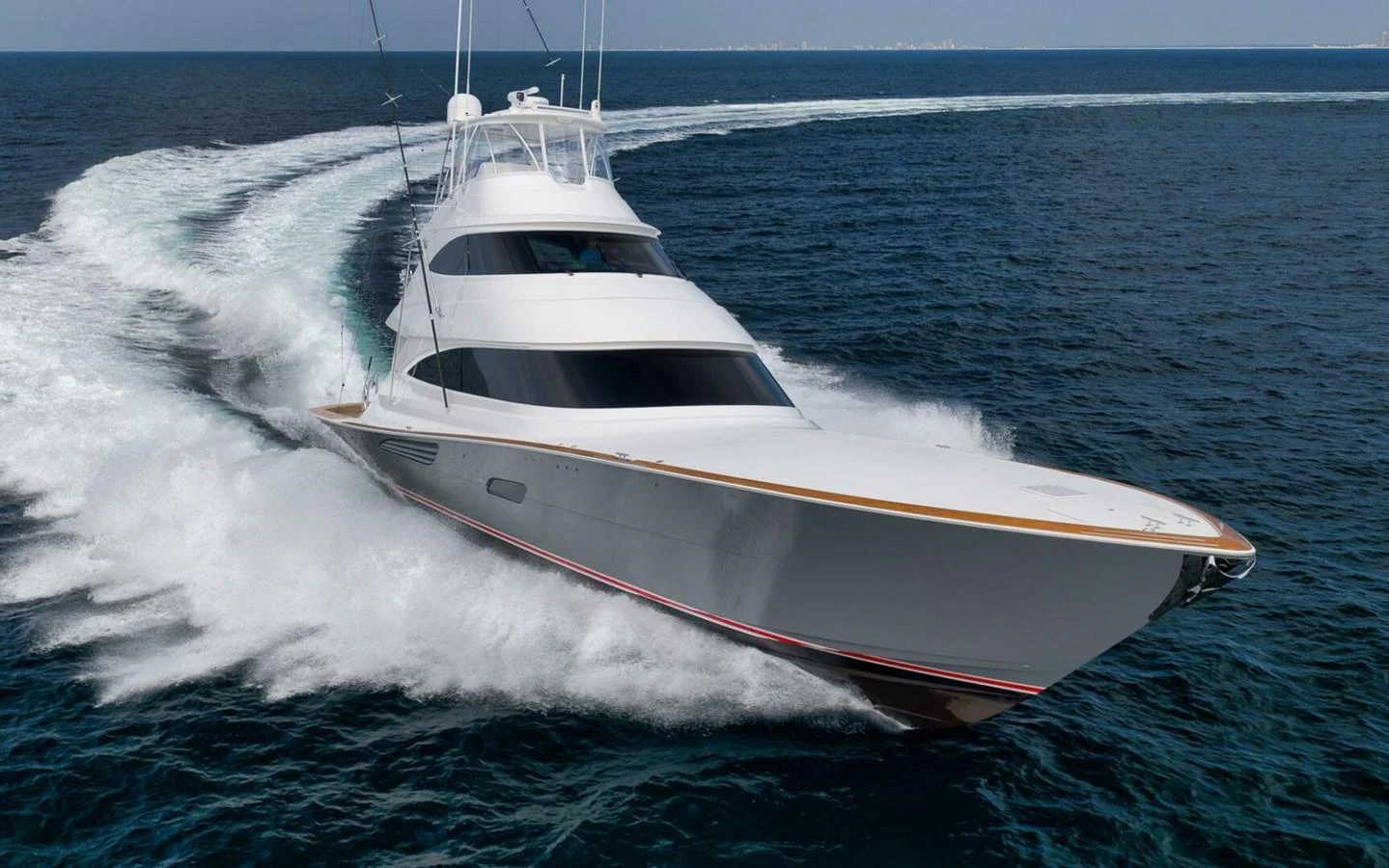 A sleek yacht cuts through the water at high speed, showcasing its powerful design and performance. aboard NIKKI BELLA Yacht for Sale