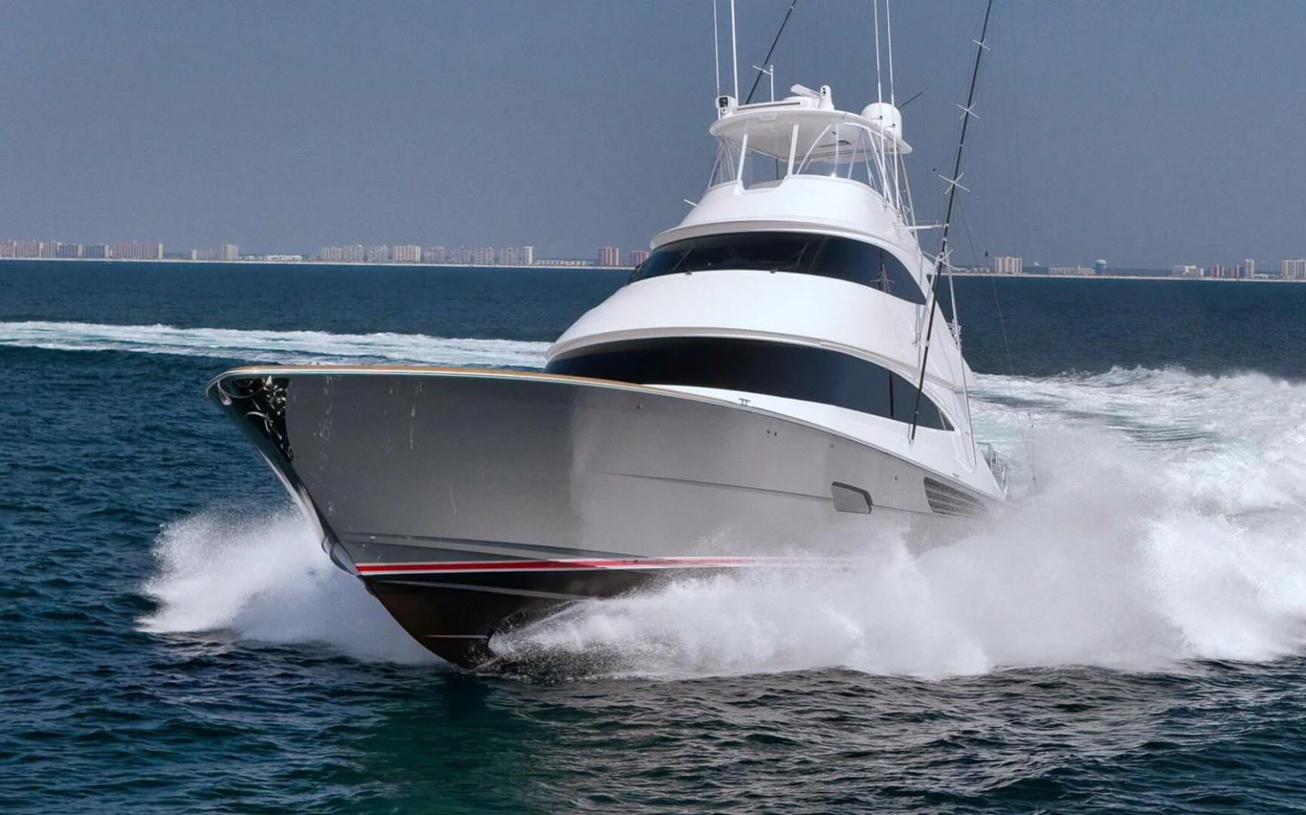 A sleek yacht cuts through the water at high speed, showcasing its powerful design and performance. aboard NIKKI BELLA Yacht for Sale