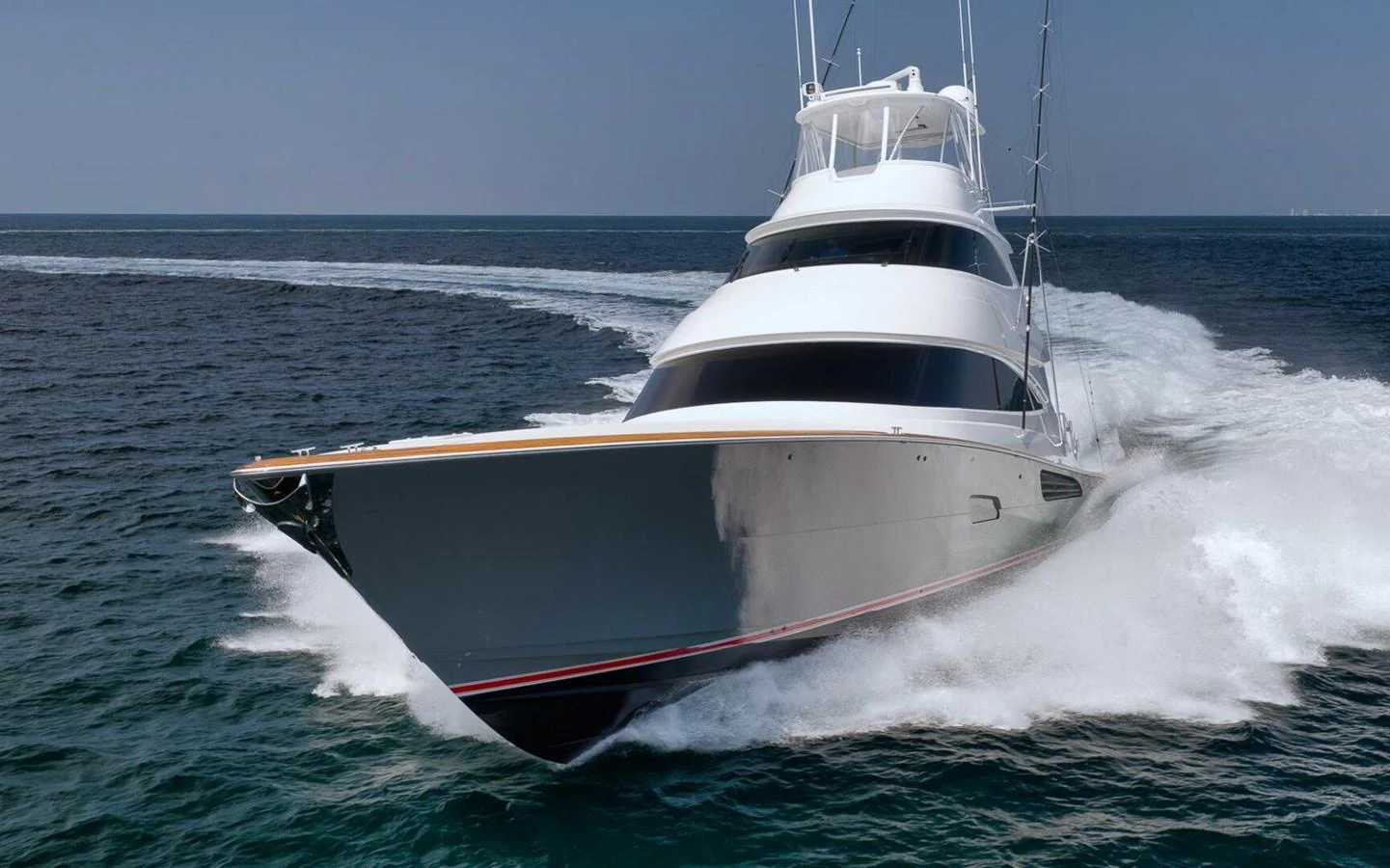A sleek yacht cuts through the water at high speed, showcasing its powerful design and performance. aboard NIKKI BELLA Yacht for Sale