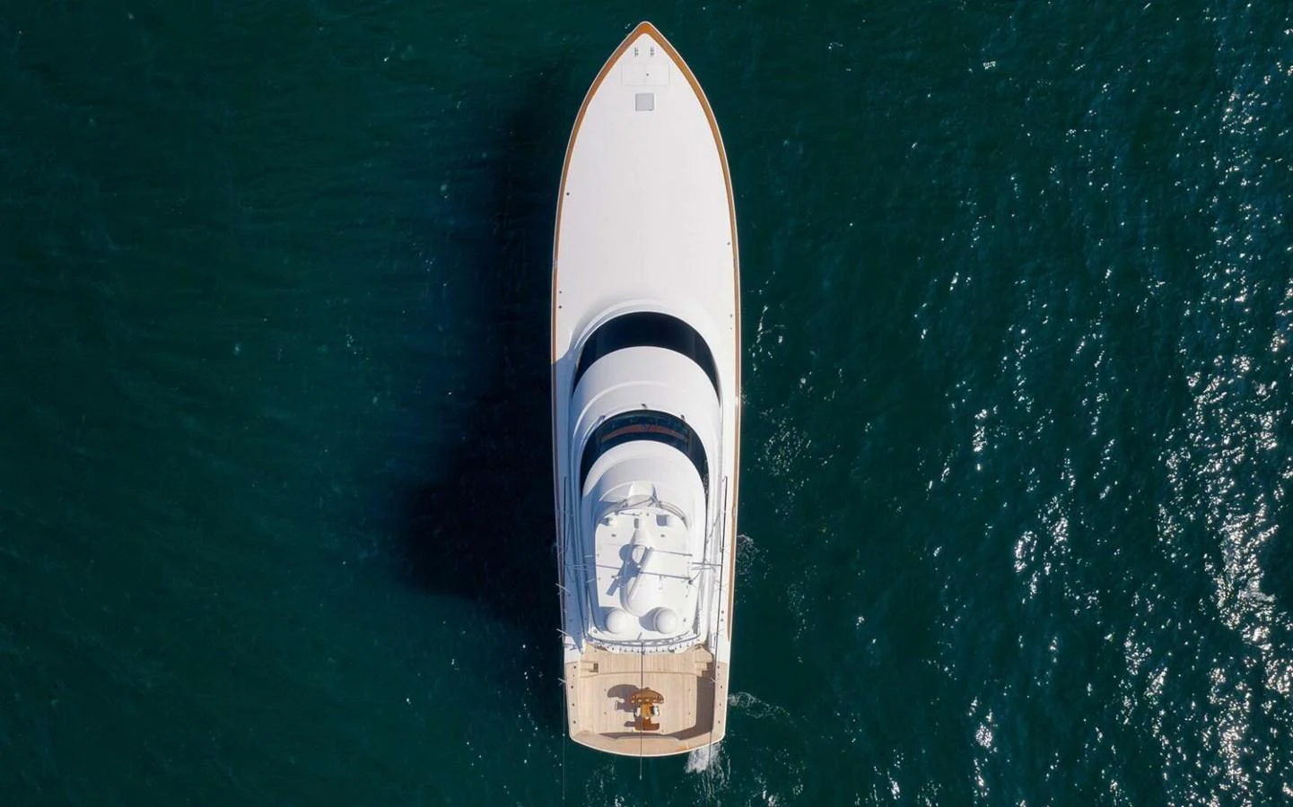 Aerial view of a sleek yacht cruising through deep blue waters. aboard NIKKI BELLA Yacht for Sale