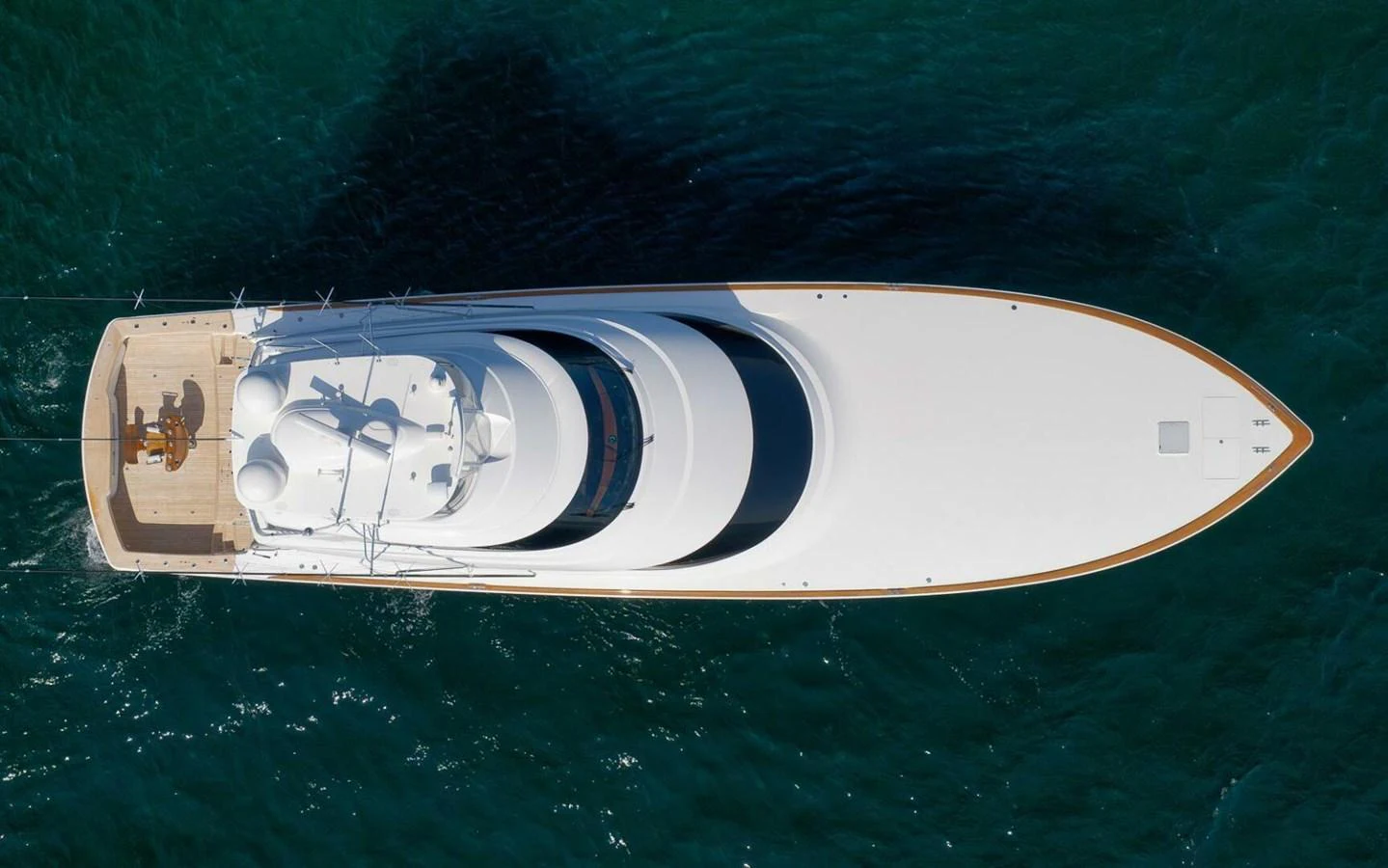 Aerial view of a sleek and modern yacht cruising through clear blue waters. aboard NIKKI BELLA Yacht for Sale