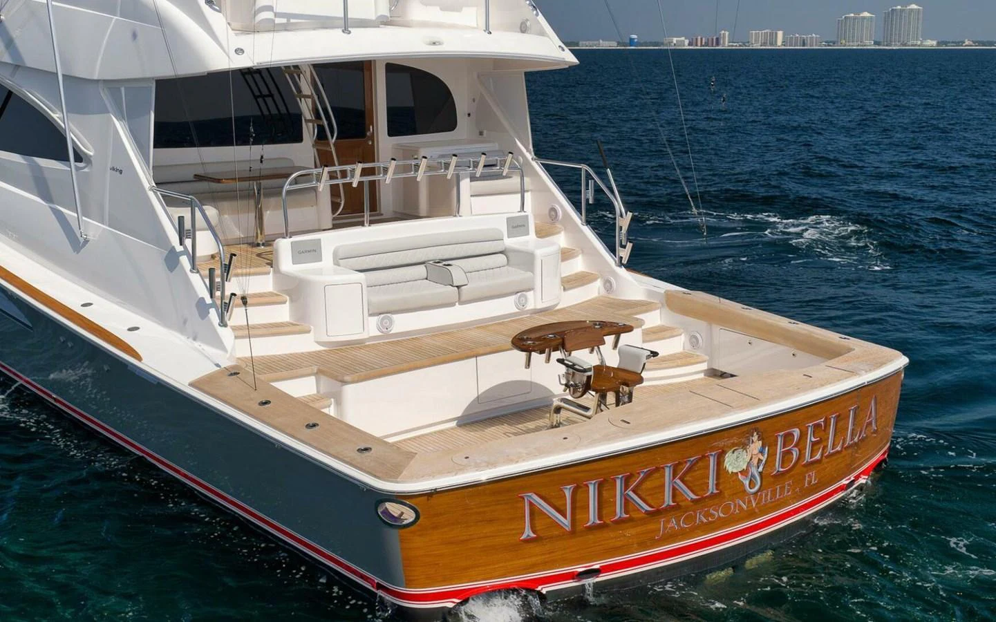 The yacht's aft deck features a spacious seating area with a table, perfect for relaxing and enjoying the view. aboard NIKKI BELLA Yacht for Sale