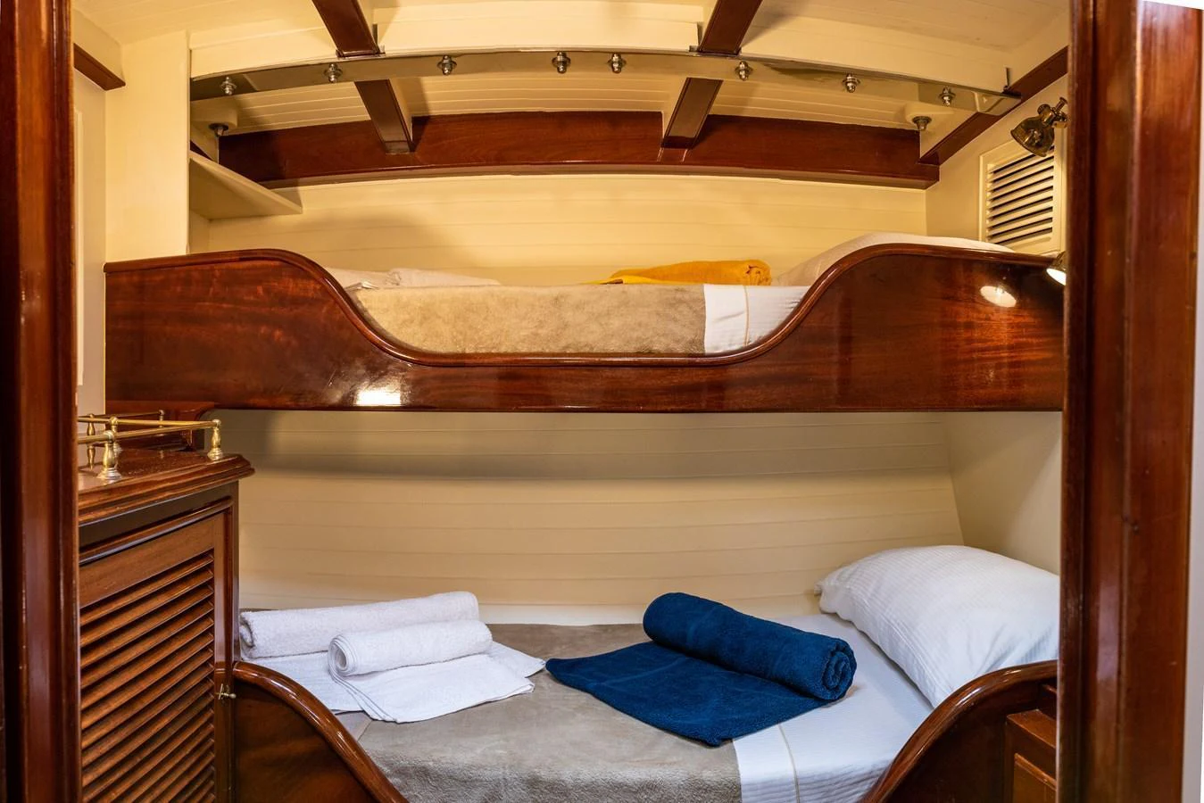 The cozy bunk cabin features warm wood finishes and comfortable bedding. aboard WHITEFIN Yacht for Sale