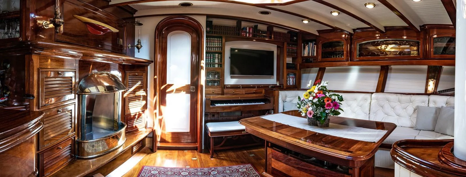 The yacht's salon features luxurious wood finishes, a cozy fireplace, and a comfortable seating area. aboard WHITEFIN Yacht for Sale