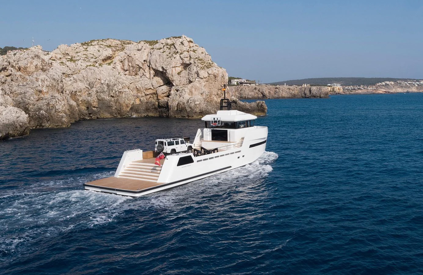 A sleek yacht cruises along a rocky coastline, showcasing its modern design and spacious deck. aboard 27 YXT Yacht for Sale