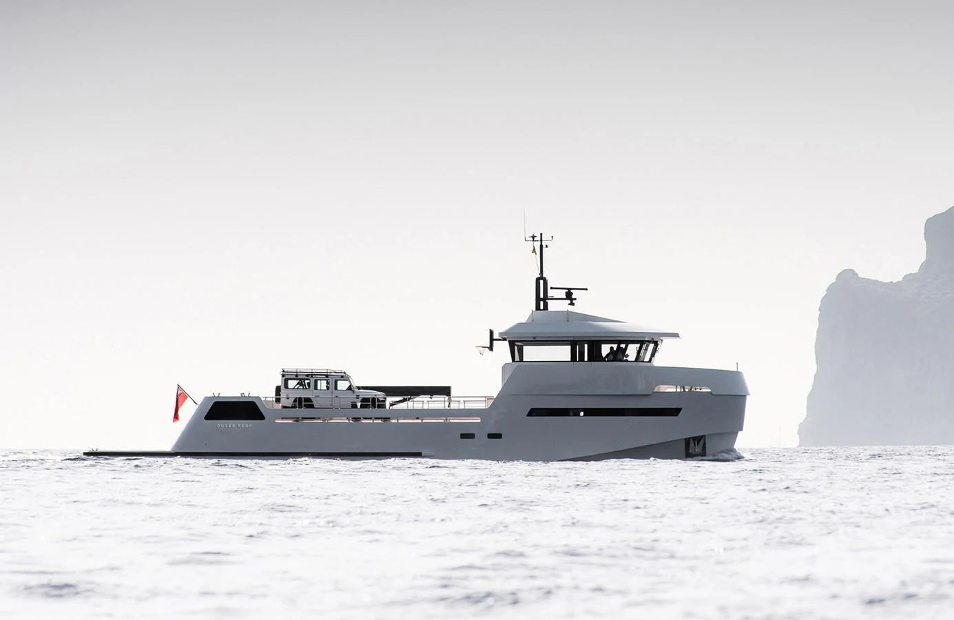 A sleek and modern yacht cruising on calm waters with a rugged coastline in the background. aboard 27 YXT Yacht for Sale