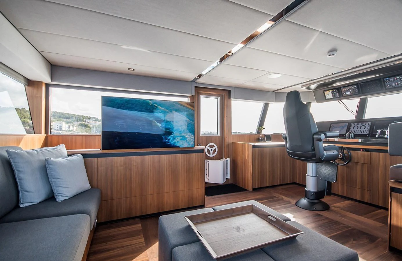 The helm area features modern controls and a comfortable seating arrangement with panoramic views. aboard 27 YXT Yacht for Sale
