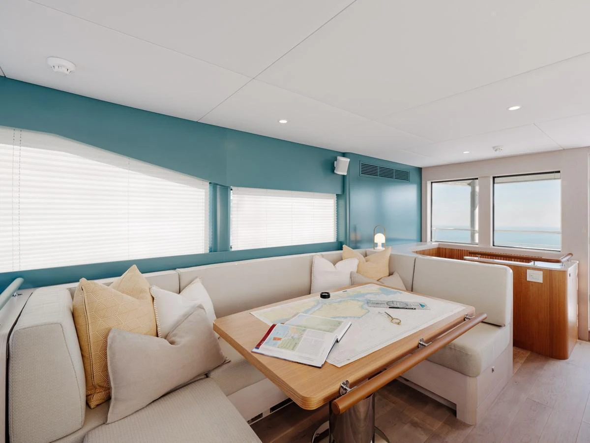 The salon features a cozy seating area with a table set for navigation and relaxation. aboard ARKSEN 85 Yacht for Sale