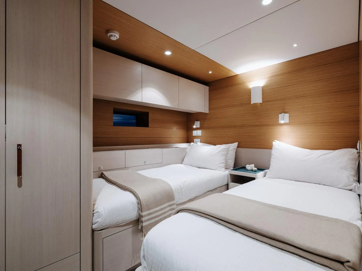 The guest stateroom features twin beds with a modern, minimalist design and warm wood accents. aboard ARKSEN 85 Yacht for Sale
