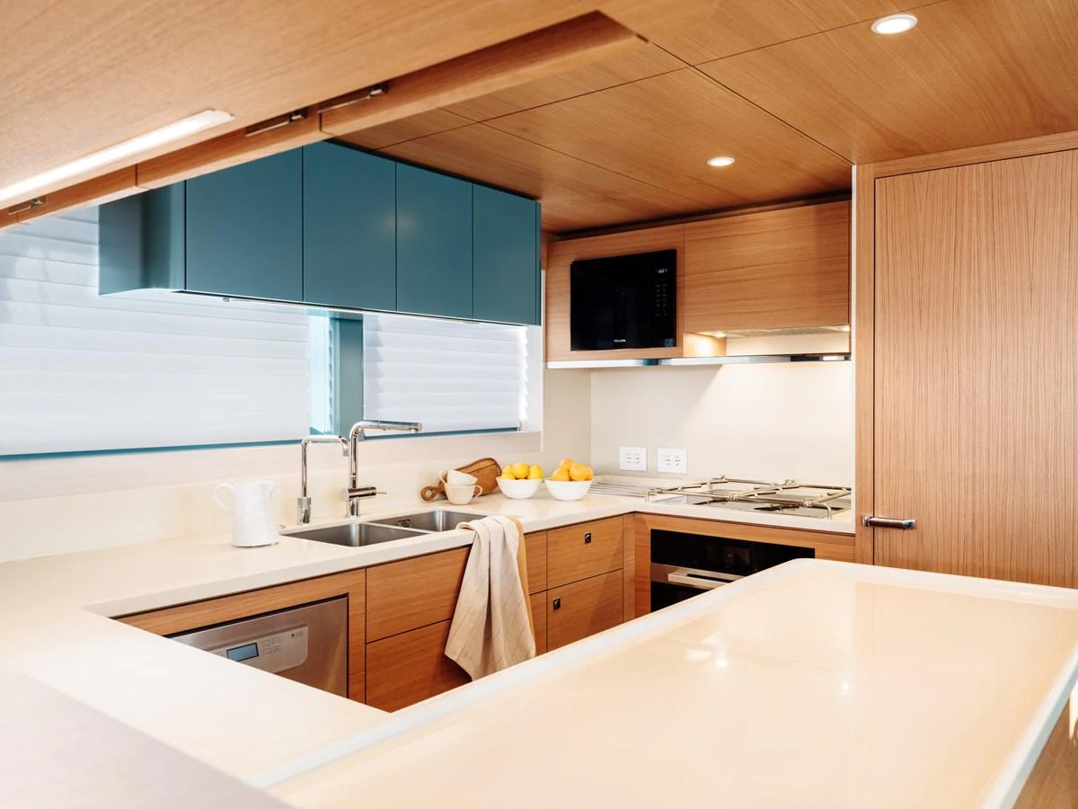 The galley features modern appliances and sleek wooden cabinetry, creating a warm and functional space. aboard ARKSEN 85 Yacht for Sale