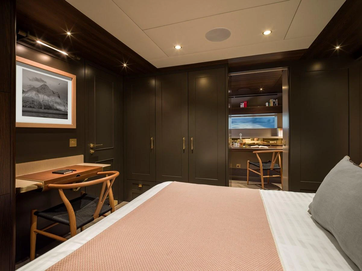 A luxurious stateroom featuring a comfortable bed, elegant furnishings, and warm lighting. aboard ARKSEN 85 Yacht for Sale