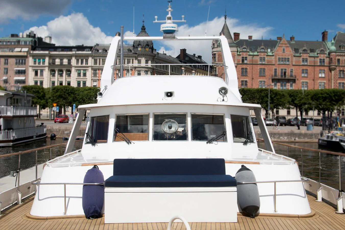The yacht's aft deck features a comfortable seating area with a scenic backdrop of a picturesque harbor. aboard STELLA NOVA Yacht for Sale