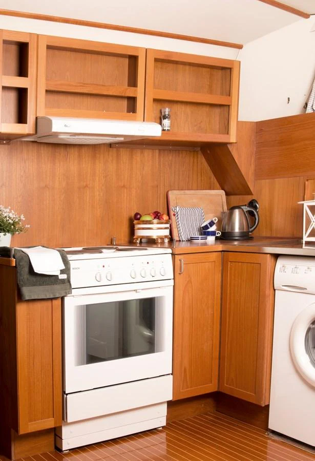 The yacht's galley features warm wood cabinetry and modern appliances, creating a cozy and functional space. aboard STELLA NOVA Yacht for Sale