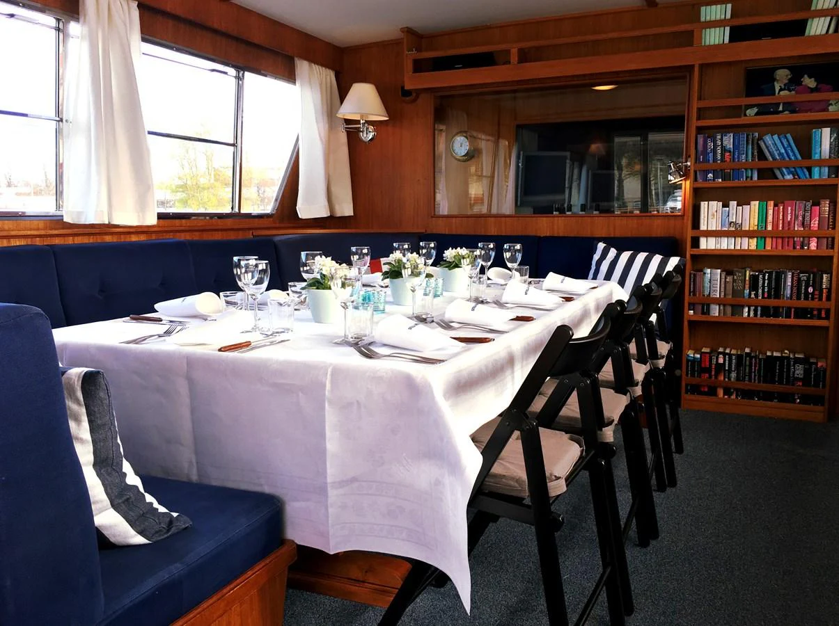 The yacht's dining area features a beautifully set table with elegant tableware and comfortable seating, creating a warm and inviting atmosphere. aboard STELLA NOVA Yacht for Sale