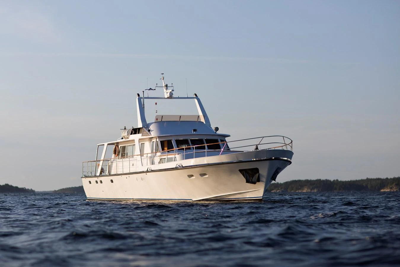 A classic motor yacht cruising on calm waters under a clear sky. aboard STELLA NOVA Yacht for Sale