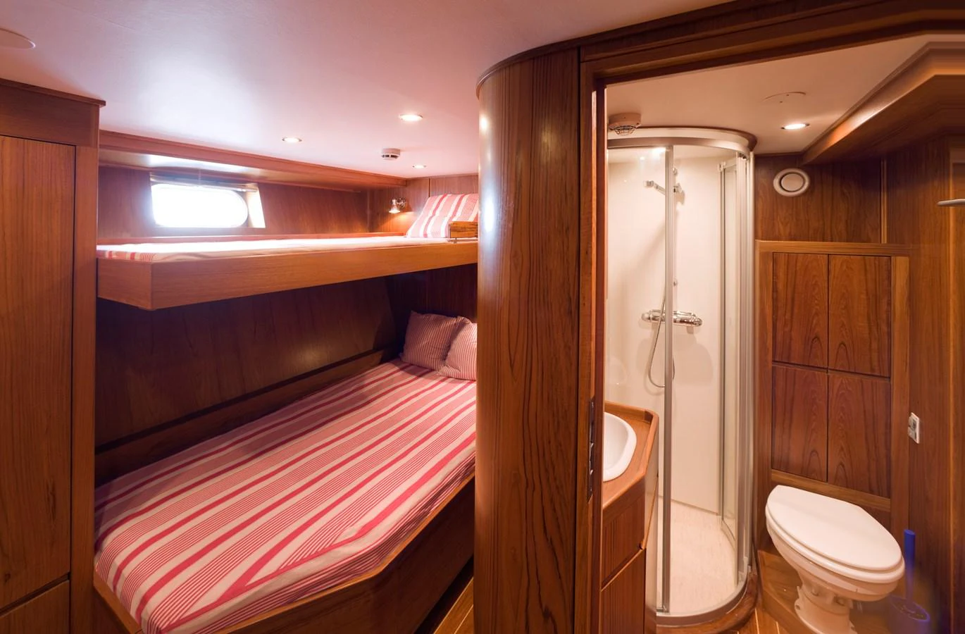 The guest cabin features cozy bunk beds and an en-suite bathroom with a shower. aboard STELLA NOVA Yacht for Sale