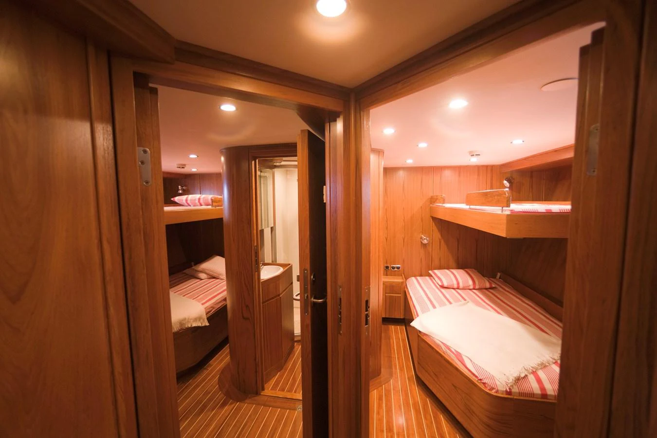 The guest cabin features cozy bunk beds with warm wooden finishes and soft lighting. aboard STELLA NOVA Yacht for Sale