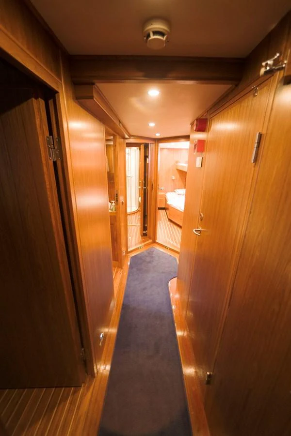 A cozy hallway with wooden paneling leads to a well-lit cabin. aboard STELLA NOVA Yacht for Sale