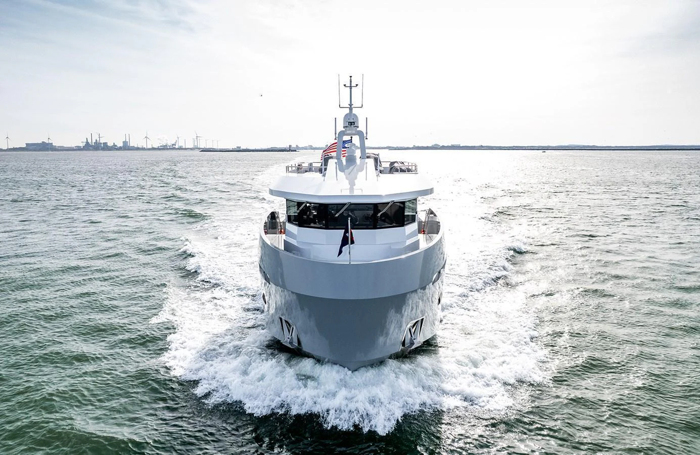 A sleek yacht cruises forward on open waters under a bright sky. aboard 27 CROSSOVER Yacht for Sale