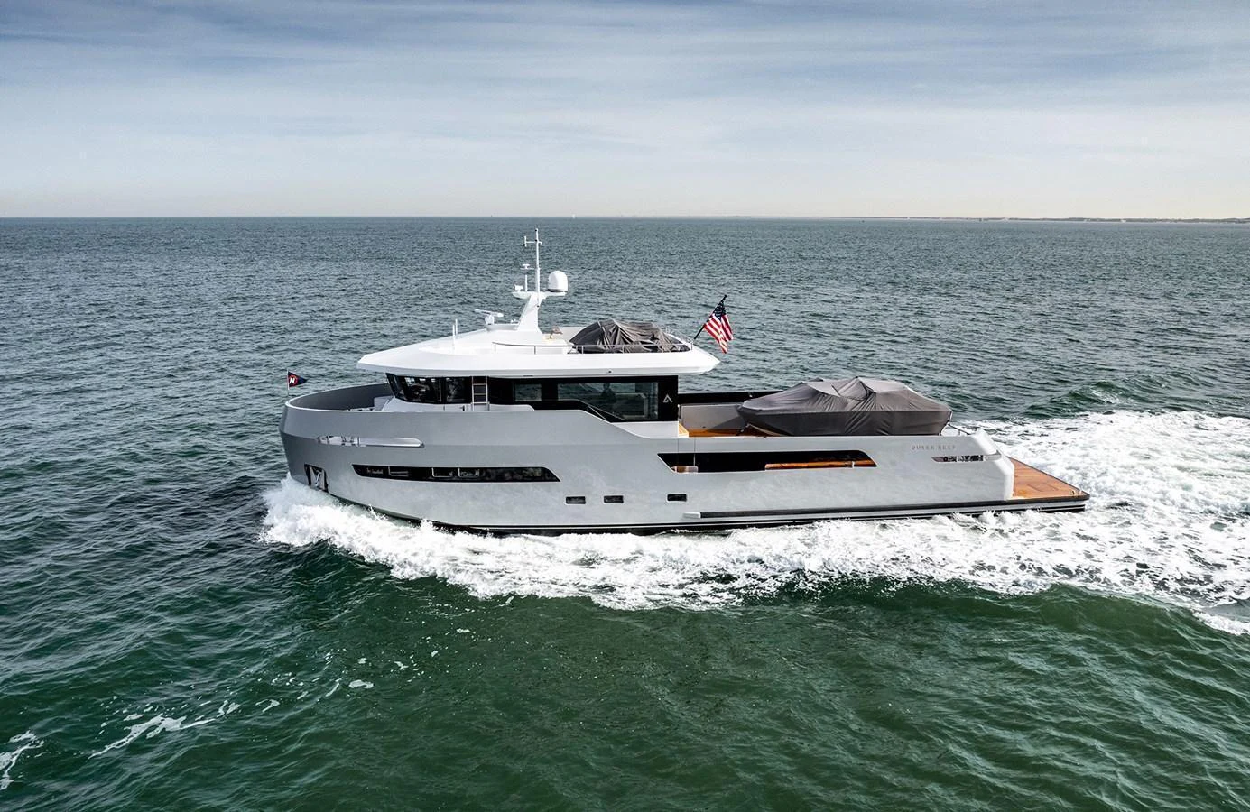 A sleek, modern yacht cruises through open waters, showcasing its elegant design and spacious deck areas. aboard 27 CROSSOVER Yacht for Sale