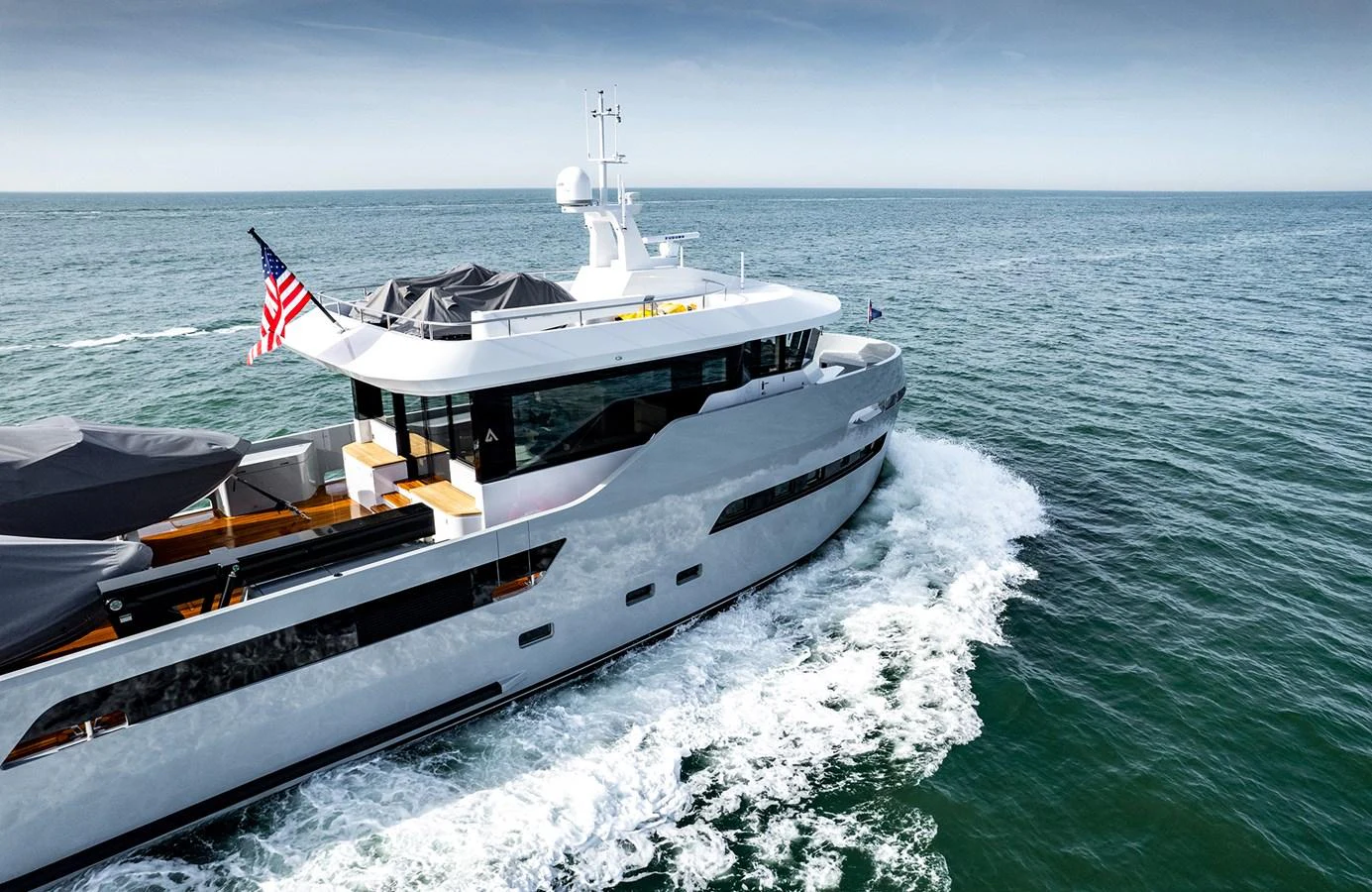 A sleek and modern yacht cruises through the open sea, showcasing its elegant design and spacious deck areas. aboard 27 CROSSOVER Yacht for Sale