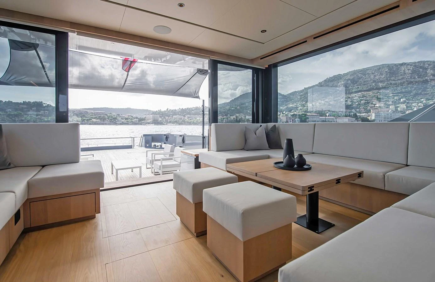 The yacht's salon features a spacious seating area with modern furnishings and large windows offering panoramic views. aboard 27 CROSSOVER Yacht for Sale