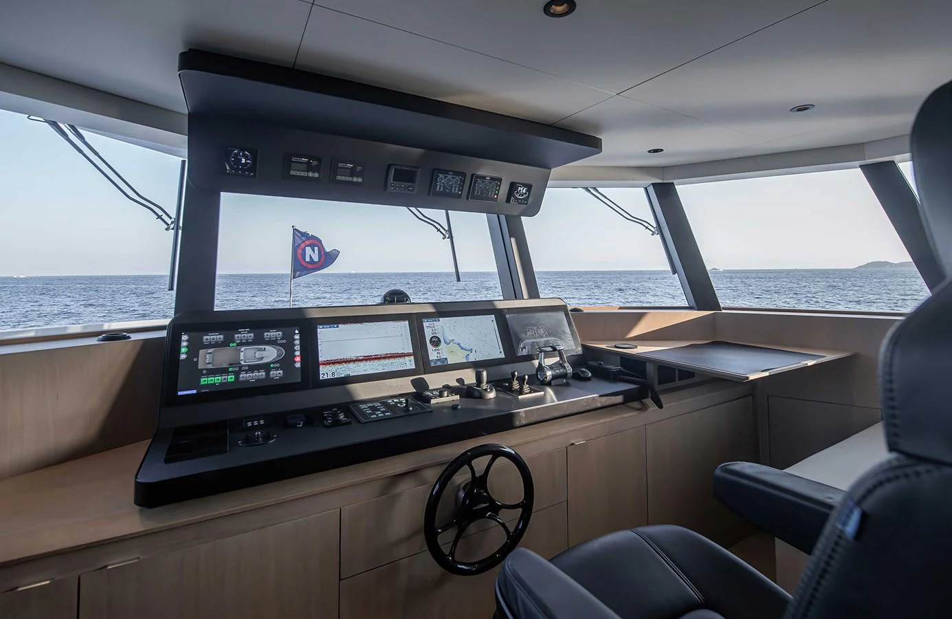 The helm station offers a commanding view with state-of-the-art navigation equipment and luxurious seating. aboard 27 CROSSOVER Yacht for Sale